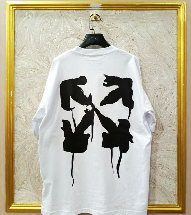 White t-shirt with "Off-White™" design on a hanger against a decorative wall.