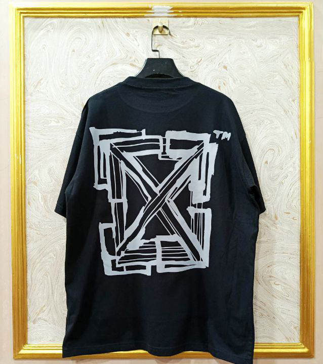 Black t-shirt with "Off-White™" design on a hanger against a decorative wall.