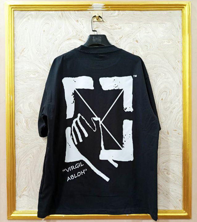 Black t-shirt with "Off-White™" design on a hanger against a decorative wall.