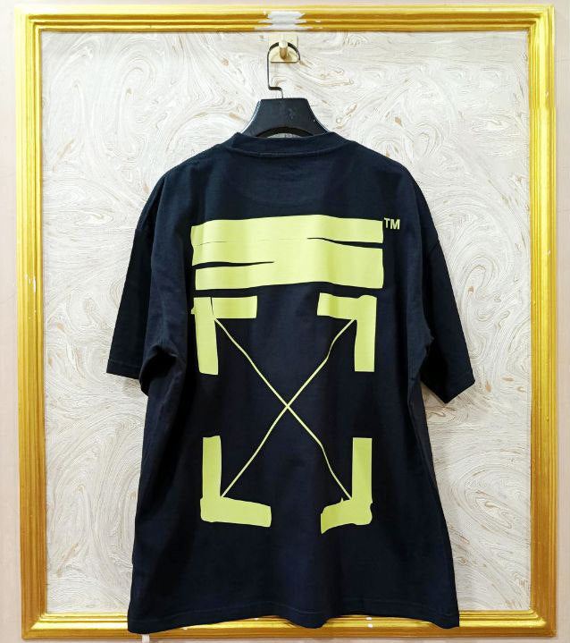 Black t-shirt with "Off-White™" design on a hanger against a decorative wall.