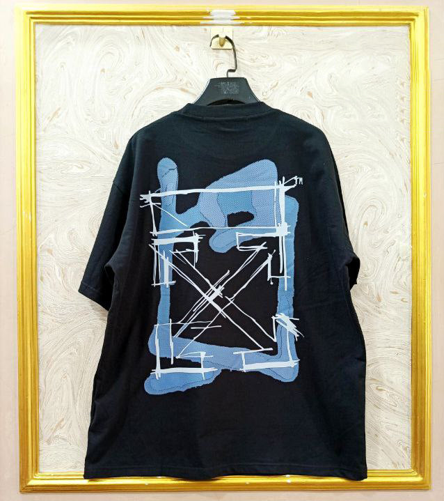 Black t-shirt with "Off-White™" design on a hanger against a decorative wall.
