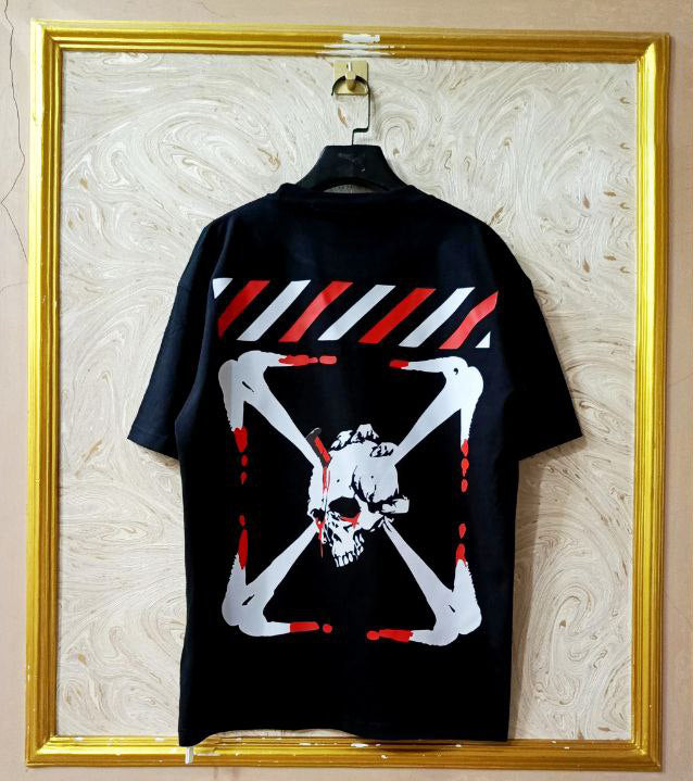 Black t-shirt with "Off-White™" design on a hanger against a decorative wall.