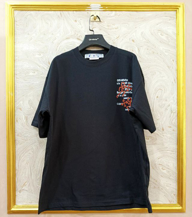 Black t-shirt with "Off-White™" logo on a hanger against a marble wall.