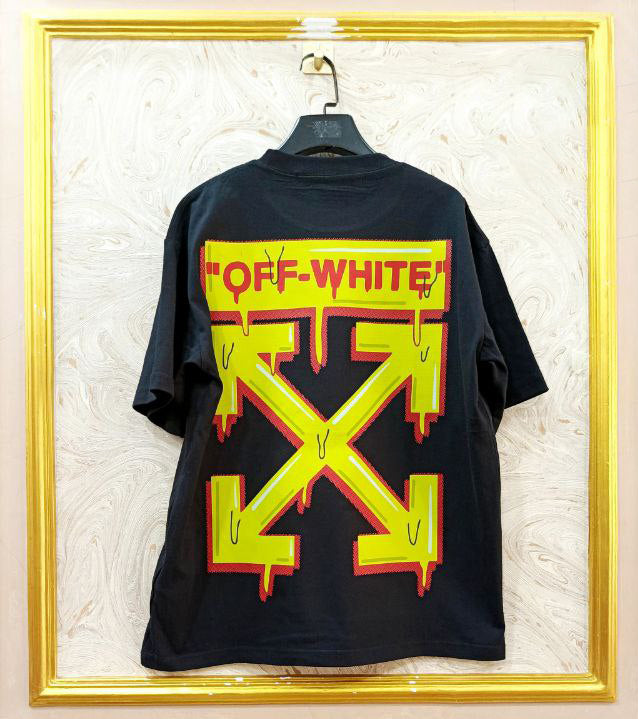 Black t-shirt with "Off-White™" design on a hanger against a decorative wall.