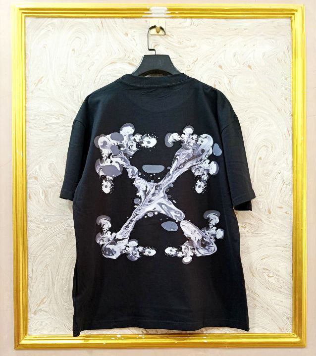 Black t-shirt with "Off-White™" design on a hanger against a decorative wall.