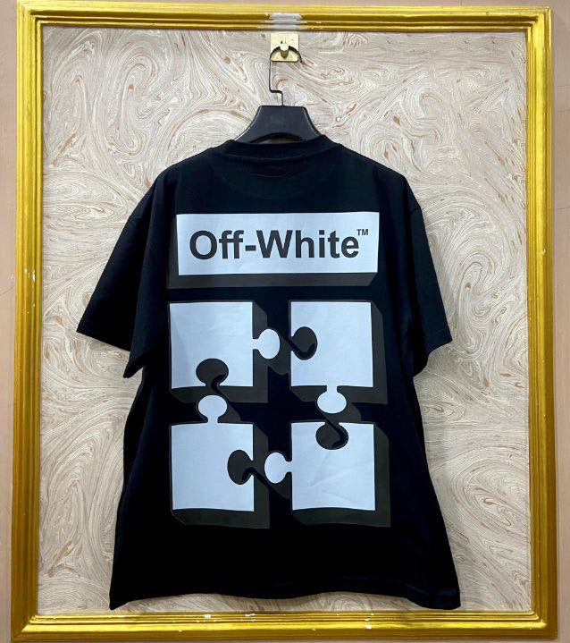Black t-shirt with "Off-White™" design on a hanger against a decorative wall.