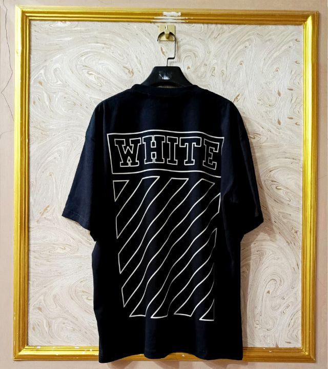 Black t-shirt with "Off-White™" design on a hanger against a decorative wall.