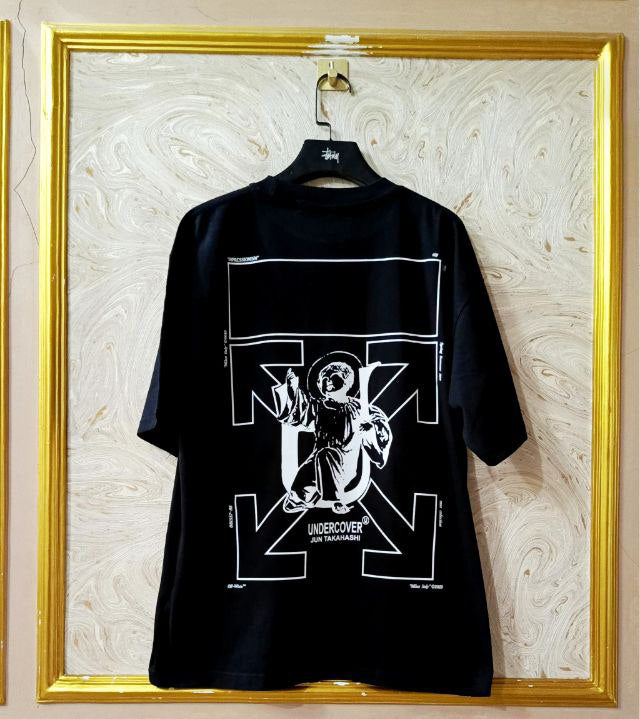 Black t-shirt with "Off-White™" design on a hanger against a decorative wall.