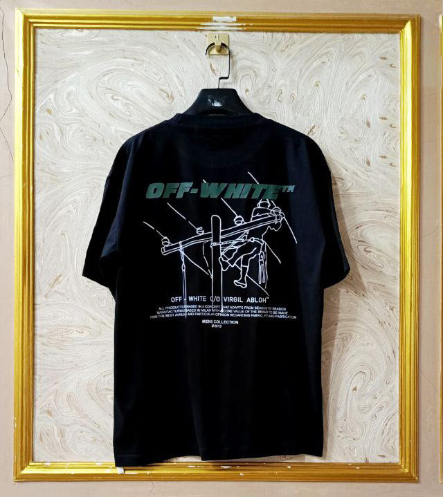 Black t-shirt with "Off-White™" design on a hanger against a decorative wall.
