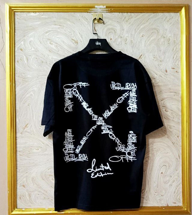 Black t-shirt with "Off-White™" design on a hanger against a decorative wall.