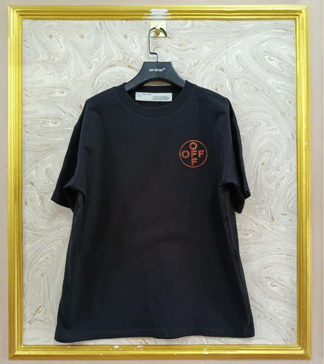 Black t-shirt with "Off-White™" logo on a hanger against a marble wall.
