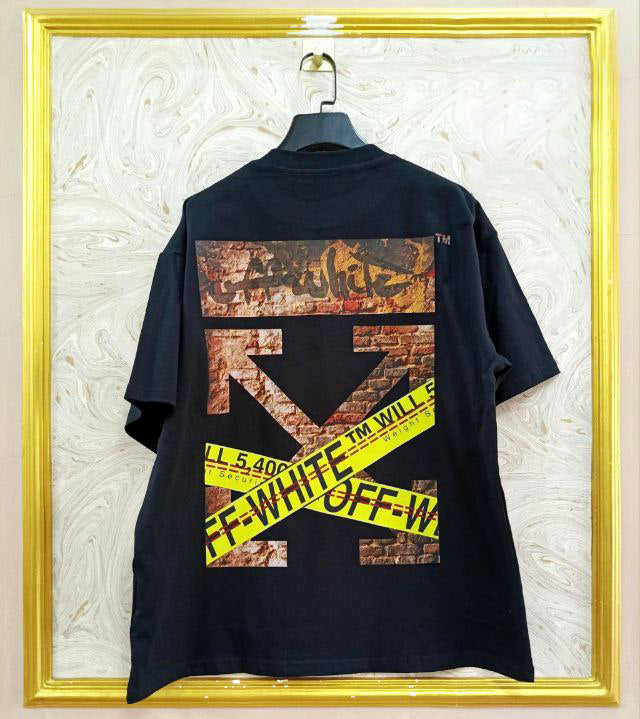 Black t-shirt with "Off-White™" design on a hanger against a decorative wall.