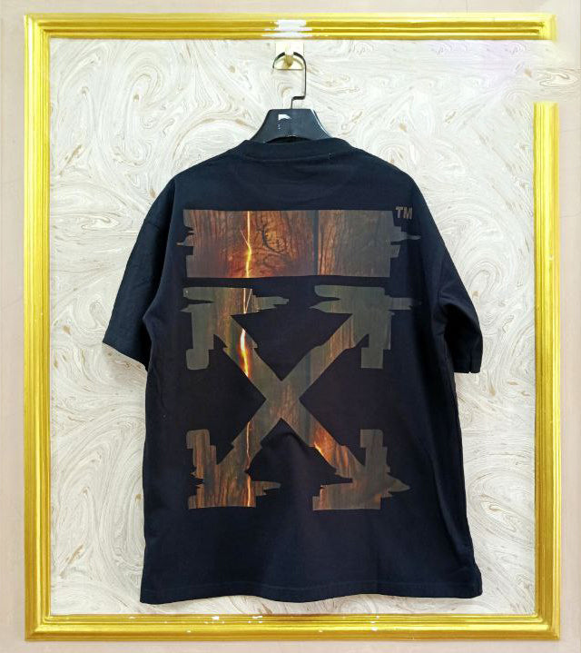 Black t-shirt with "Off-White™" design on a hanger against a decorative wall.