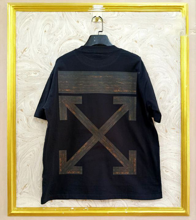 Black t-shirt with "Off-White™" design on a hanger against a decorative wall.