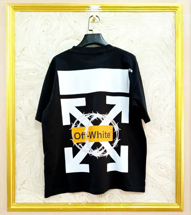 Black t-shirt with "Off-White™" design on a hanger against a decorative wall.