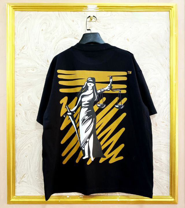 Black t-shirt with "Off-White™" design on a hanger against a decorative wall.