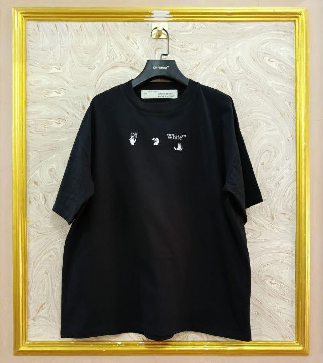 Black t-shirt with "Off-White™" logo on a hanger against a marble wall.