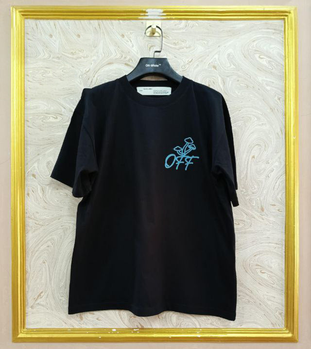 Black t-shirt with "Off-White™" logo on a hanger against a marble wall.