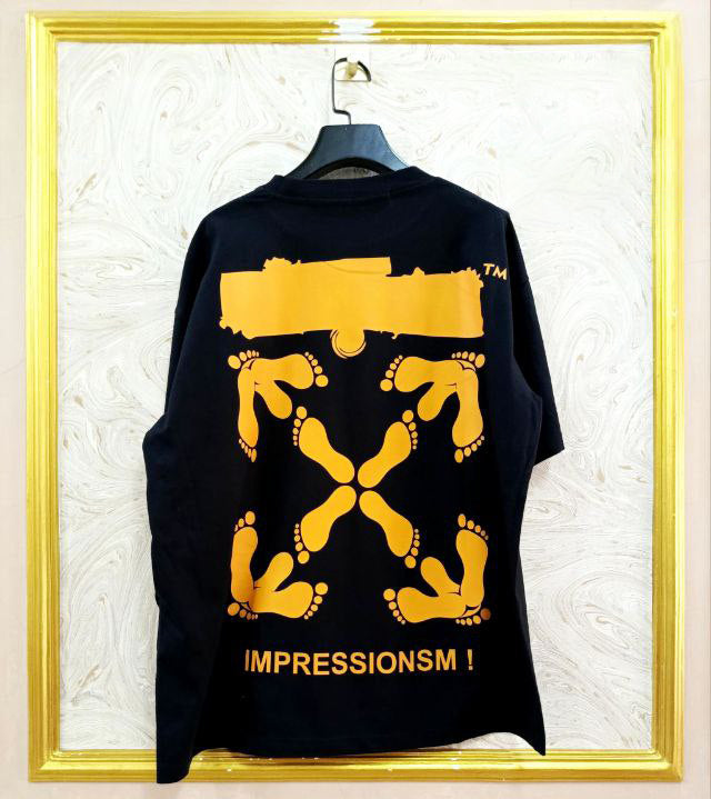 Black t-shirt with "Off-White™" design on a hanger against a decorative wall.