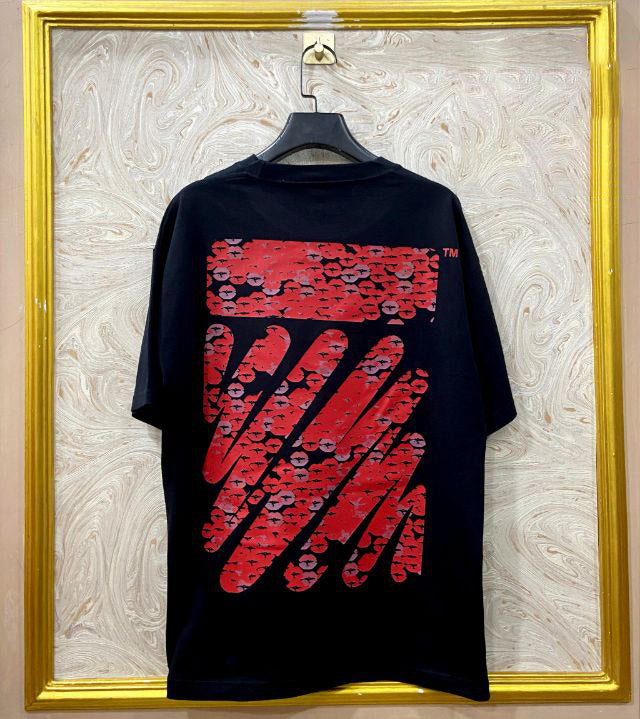Black t-shirt with "Off-White™" design on a hanger against a decorative wall.