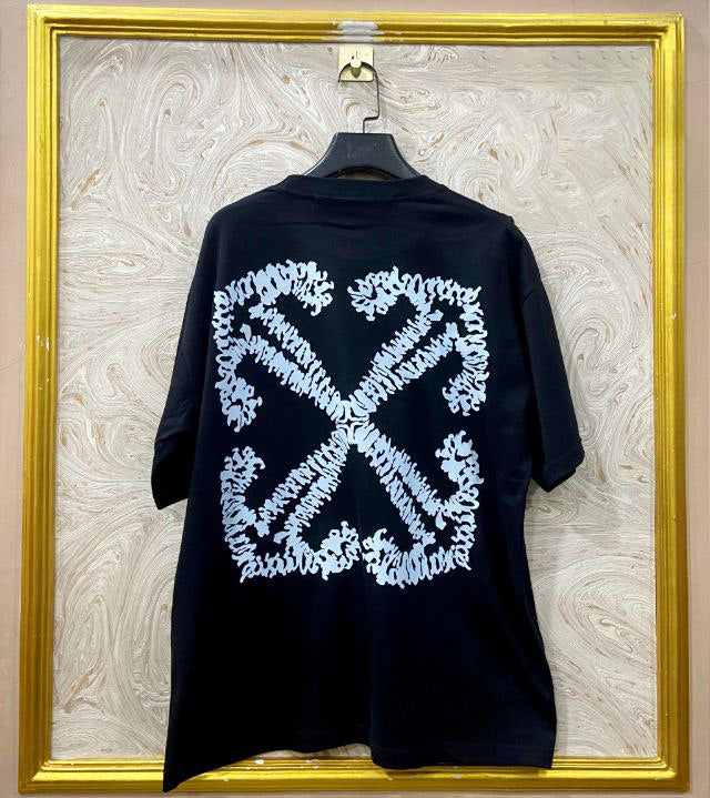 Black t-shirt with "Off-White™" design on a hanger against a decorative wall.