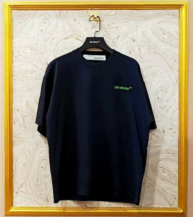 Black t-shirt with "Off-White™" logo on a hanger against a marble wall.