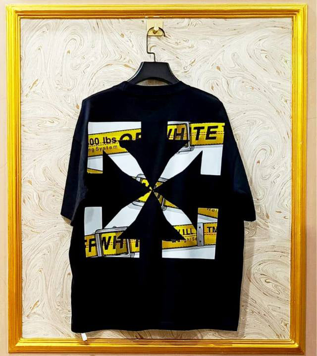 Black t-shirt with "Off-White™" design on a hanger against a decorative wall.