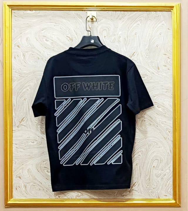 Black t-shirt with "Off-White™" design on a hanger against a decorative wall.