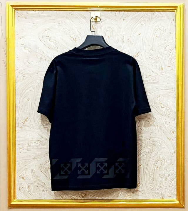 Black t-shirt with "Off-White™" design on a hanger against a decorative wall.