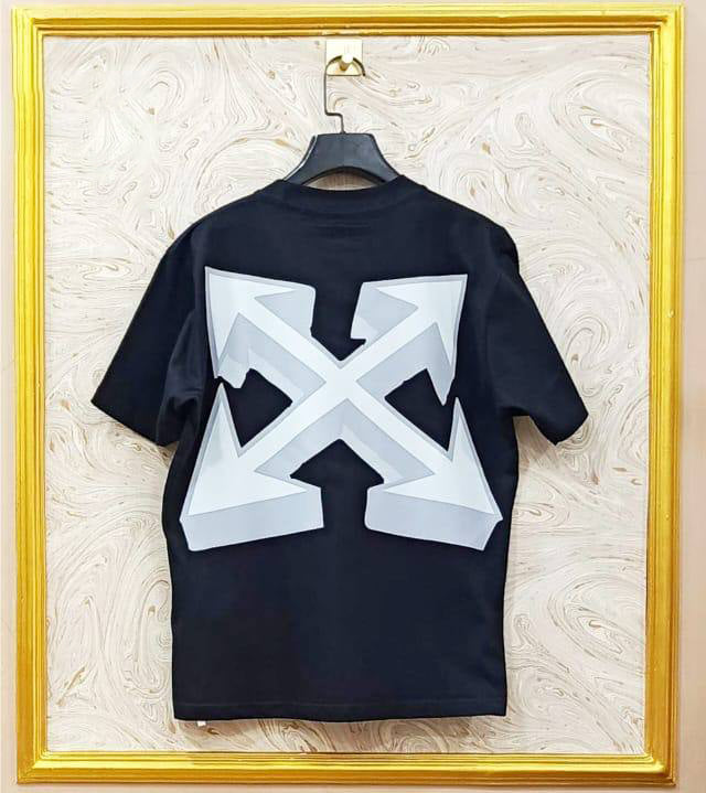 Black t-shirt with "Off-White™" design on a hanger against a decorative wall.