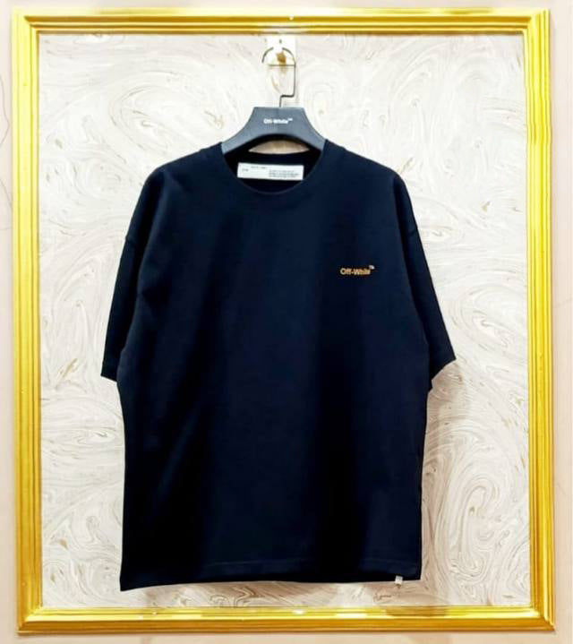 Black t-shirt with "Off-White™" logo on a hanger against a marble wall.