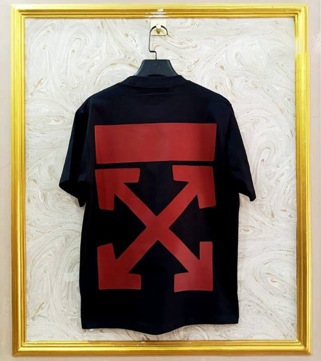 Black t-shirt with "Off-White™" design on a hanger against a decorative wall.