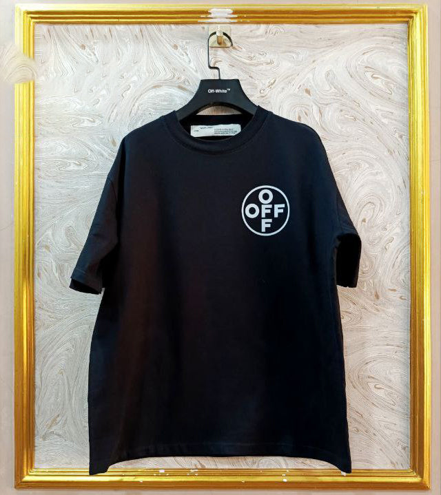 Black t-shirt with "Off-White™" logo on a hanger against a marble wall.