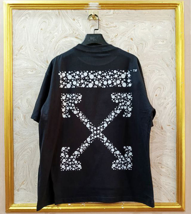 Black t-shirt with "Off-White™" design on a hanger against a decorative wall.