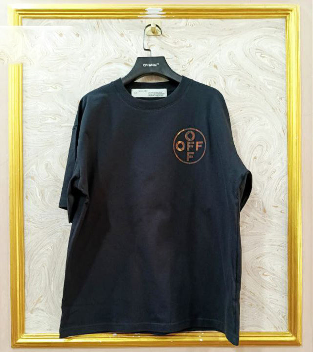 Black t-shirt with "Off-White™" logo on a hanger against a marble wall.