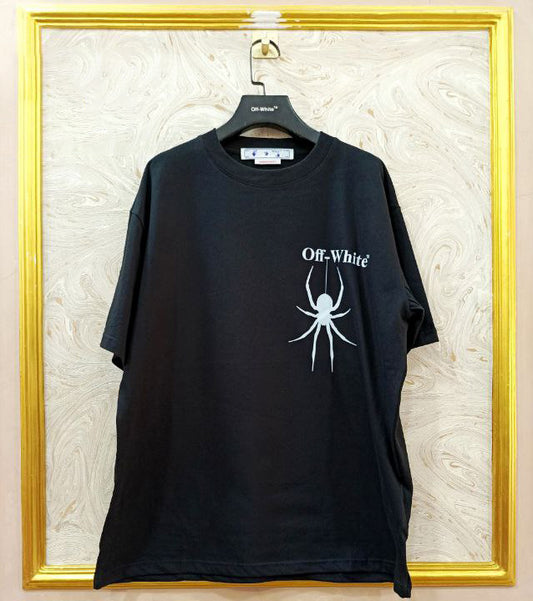 Black t-shirt with "Off-White™" logo on a hanger against a marble wall.