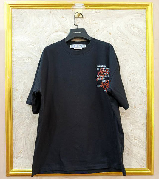 Black t-shirt with "Off-White™" logo on a hanger against a marble wall.