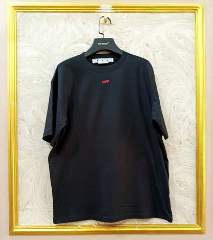 Black t-shirt with "Off-White™" logo on a hanger against a marble wall.