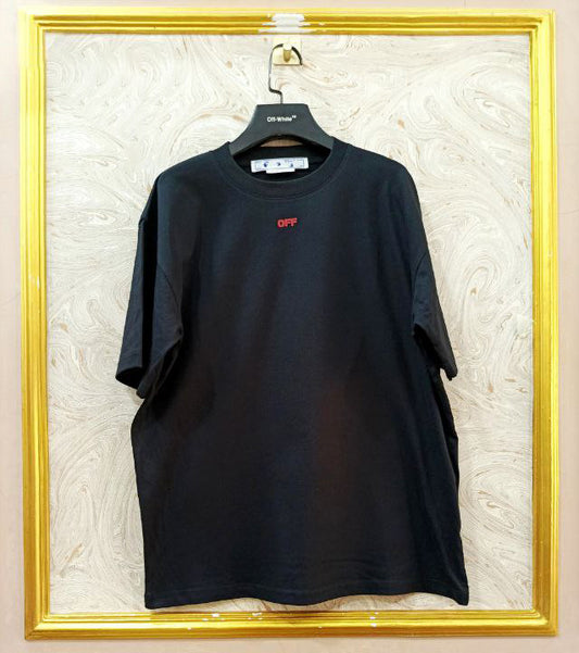Black t-shirt with "Off-White™" logo on a hanger against a marble wall.