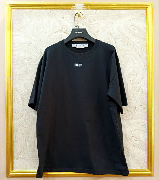 Black t-shirt with "Off-White™" logo on a hanger against a marble wall.