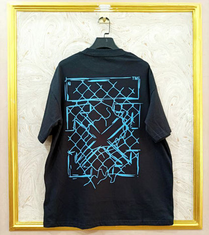 Black t-shirt with "Off-White™" design on a hanger against a decorative wall.
