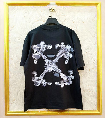 Black t-shirt with "Off-White™" design on a hanger against a decorative wall.