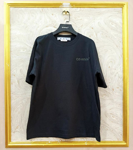Black t-shirt with "Off-White™" logo on a hanger against a marble wall.