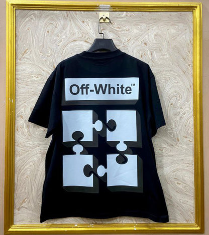 Black t-shirt with "Off-White™" design on a hanger against a decorative wall.