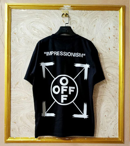 Black t-shirt with "Off-White™" design on a hanger against a decorative wall.