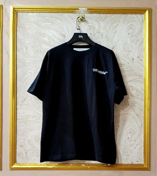 Black t-shirt with "Off-White™" logo on a hanger against a marble wall.