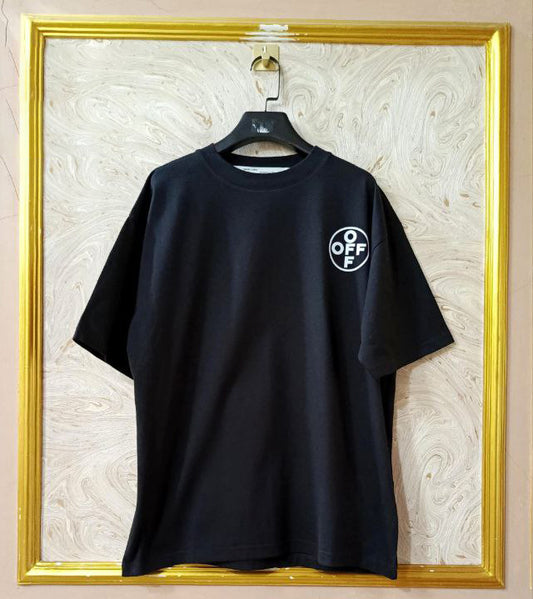 Black t-shirt with "Off-White™" logo on a hanger against a marble wall.