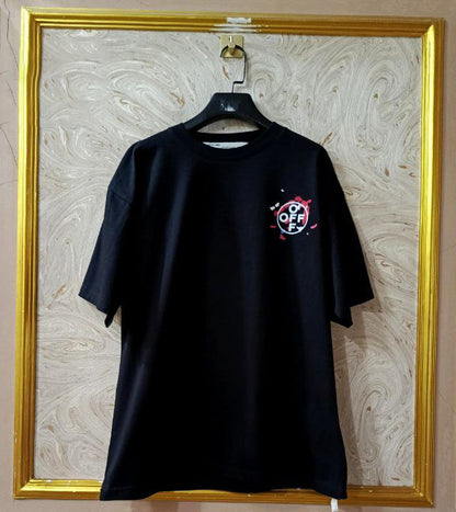 Black t-shirt with "Off-White™" logo on a hanger against a marble wall.