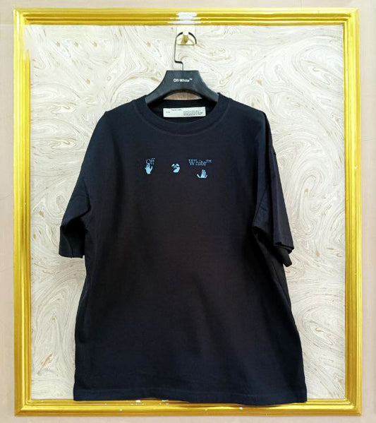 Black t-shirt with "Off-White™" logo on a hanger against a marble wall.
