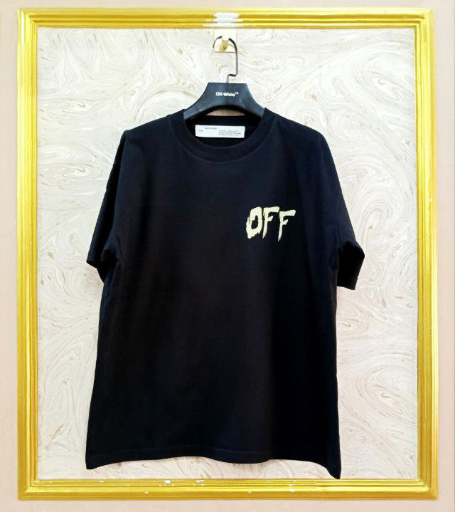 Black t-shirt with "Off-White™" logo on a hanger against a marble wall.
